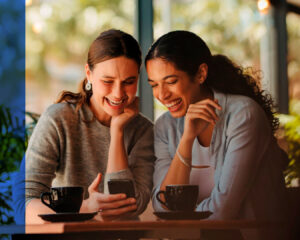 Chicas jovenes riéndose mientras miran el celular